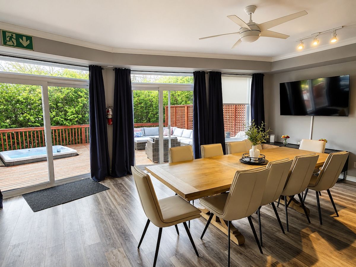 Dining table for a big group beside sliding doors that open onto the deck and hot tub